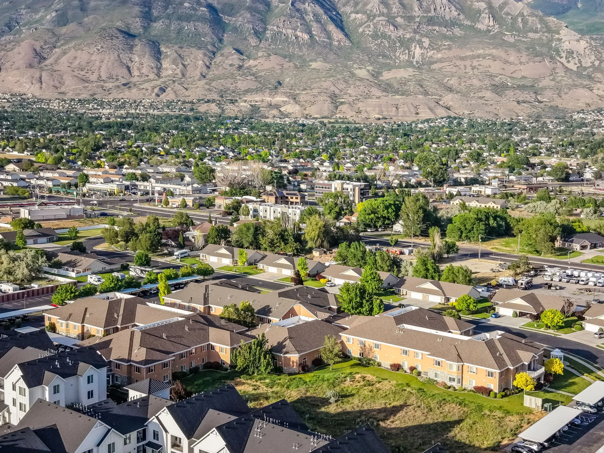 Community setting with varied residential architecture and established landscaping, framed by a mountainous backdrop