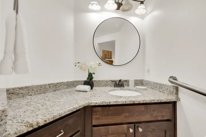 Bathroom vanity featuring an undermount sink, granite countertop, and dark wood-finish cabinetry