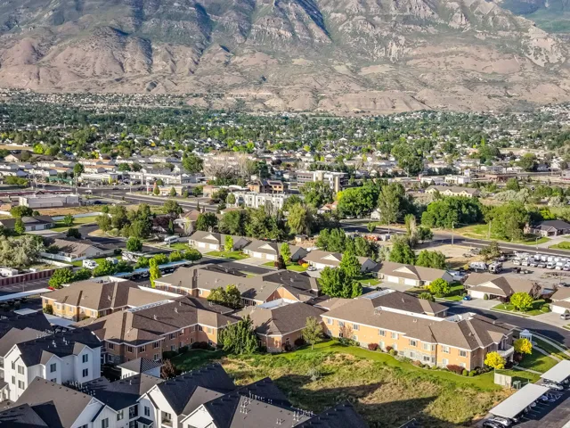 Community setting with varied residential architecture and established landscaping, framed by a mountainous backdrop