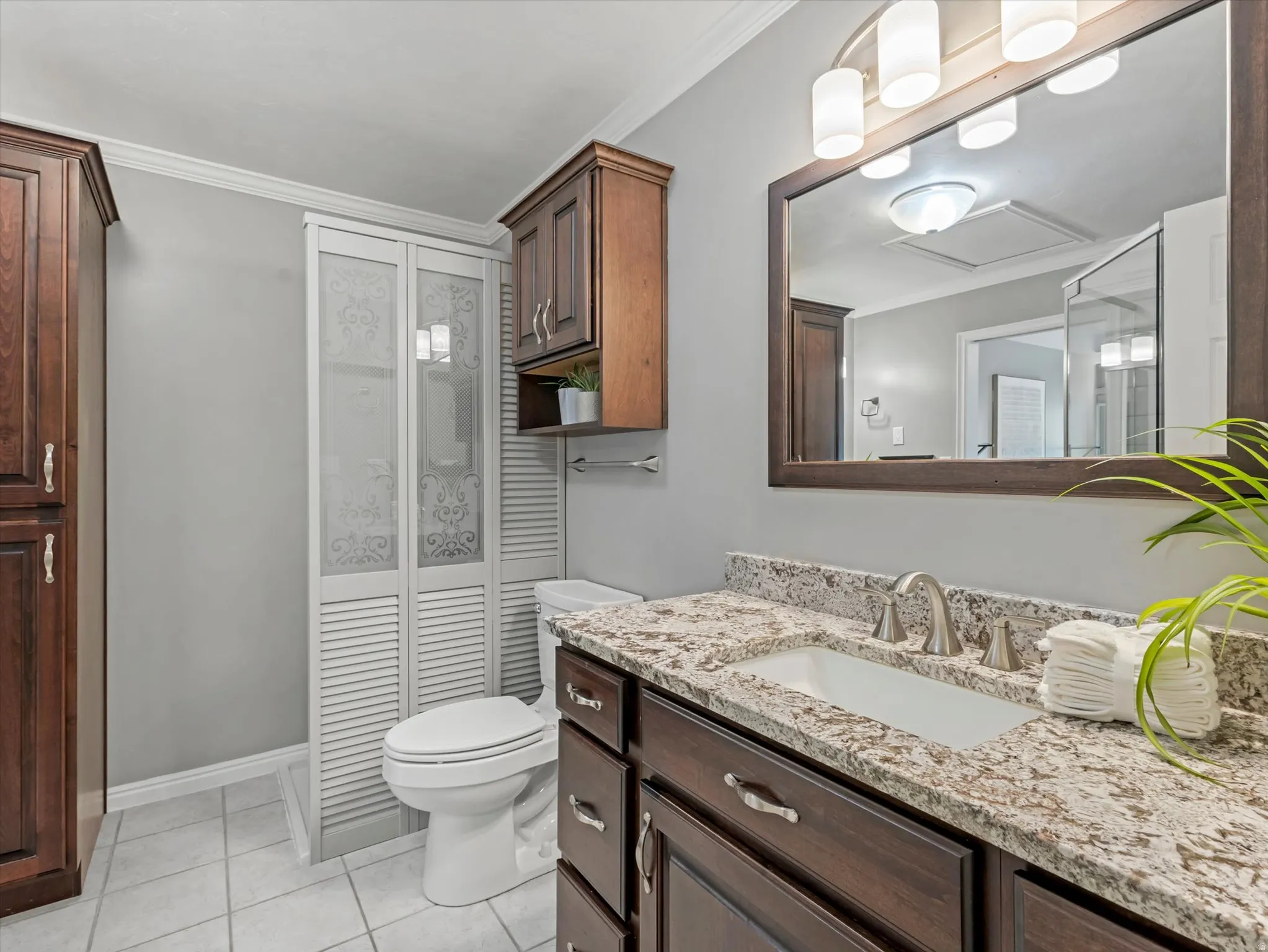 Vanity featuring a rectangular undermount sink, a granite-look countertop, and dark wood cabinetry