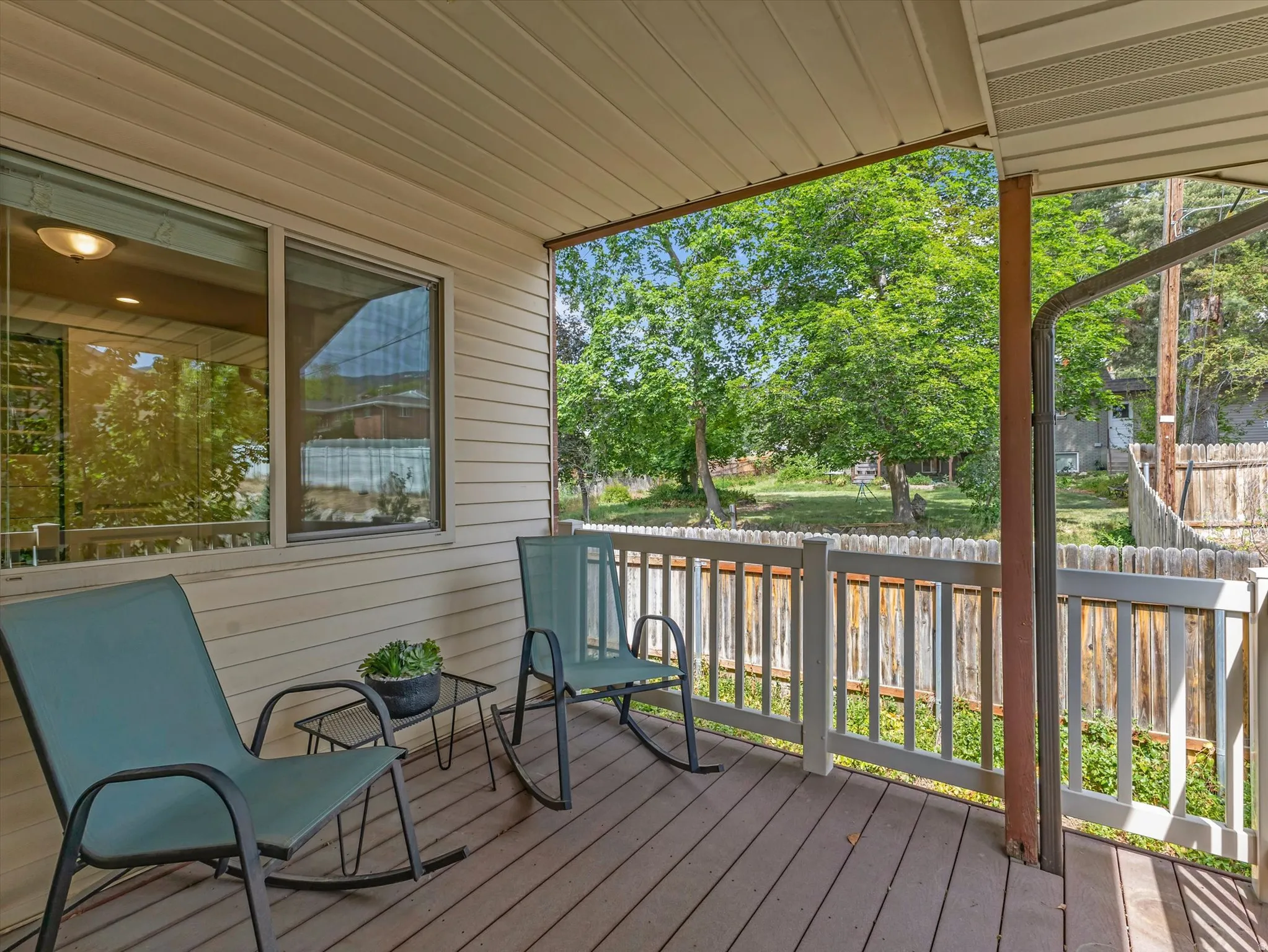 Covered porch featuring wood-finish decking, horizontal siding, and a white railing