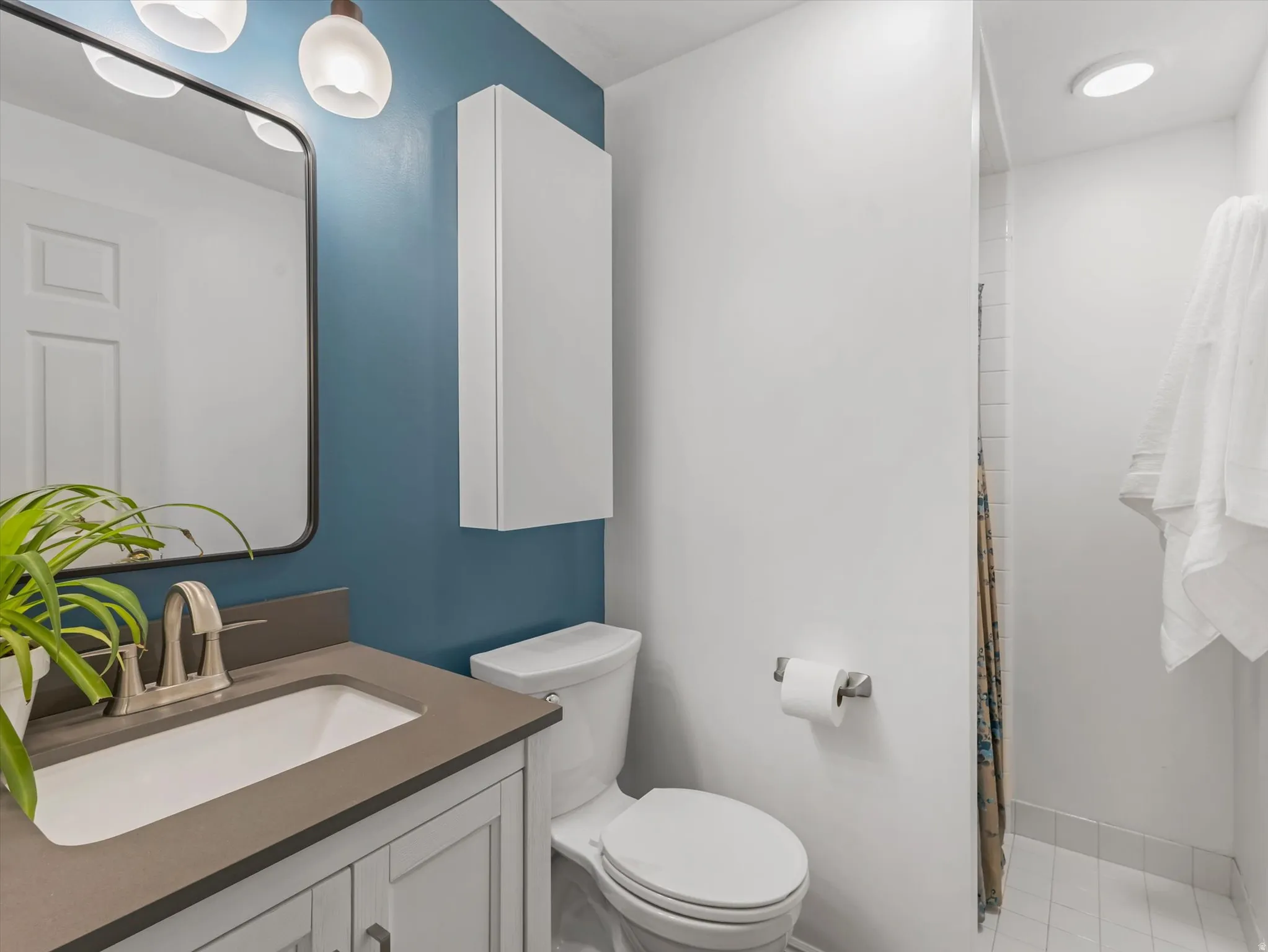 Bathroom featuring a contemporary vanity with a rectangular sink and brushed nickel faucet, complemented by a large framed mirror