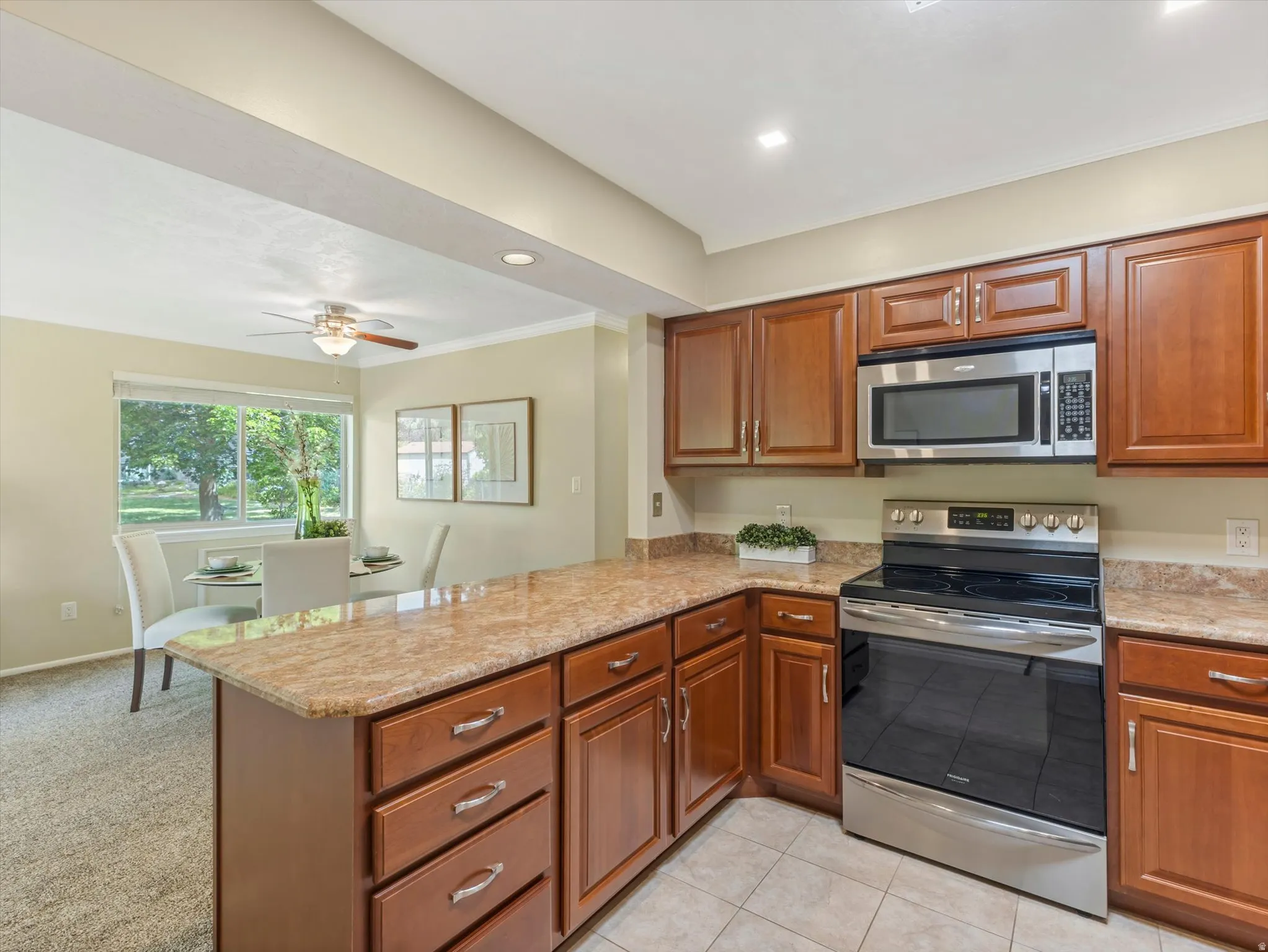 Kitchen featuring wood cabinetry, light-toned countertops, and stainless steel appliances
