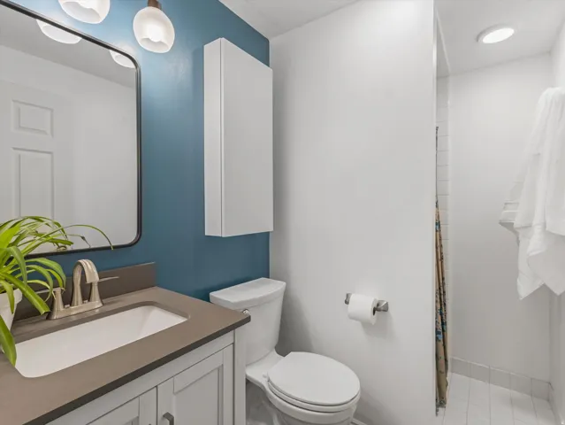 Bathroom featuring a contemporary vanity with a rectangular sink and brushed nickel faucet, complemented by a large framed mirror
