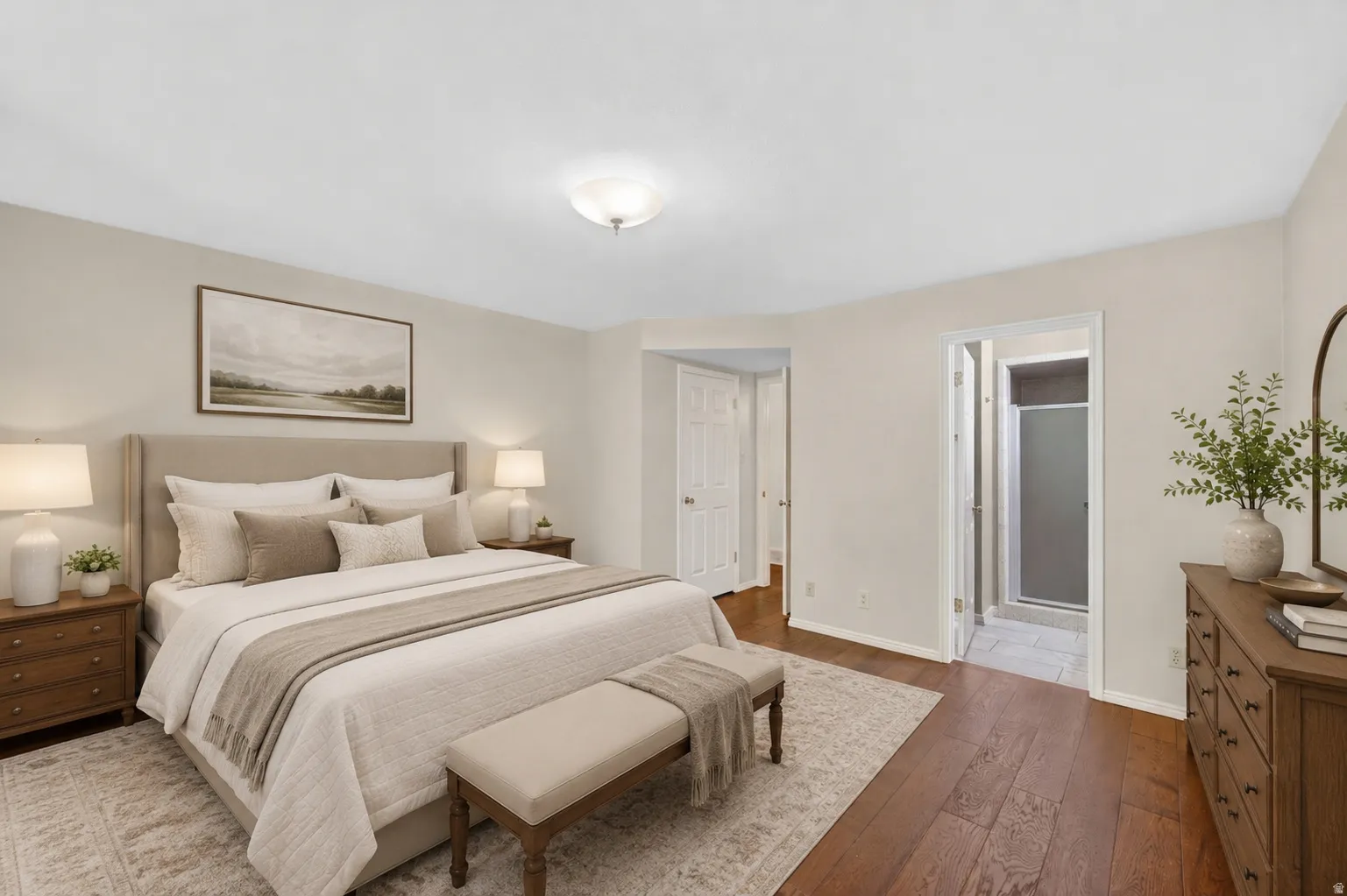 Spacious bedroom featuring wood-finish flooring, light-toned wall finishes, and a flush-mount ceiling fixture