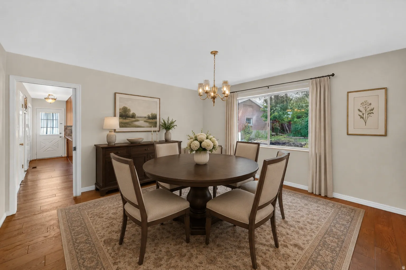 Dining area featuring wood-finish flooring and a central brass chandelier