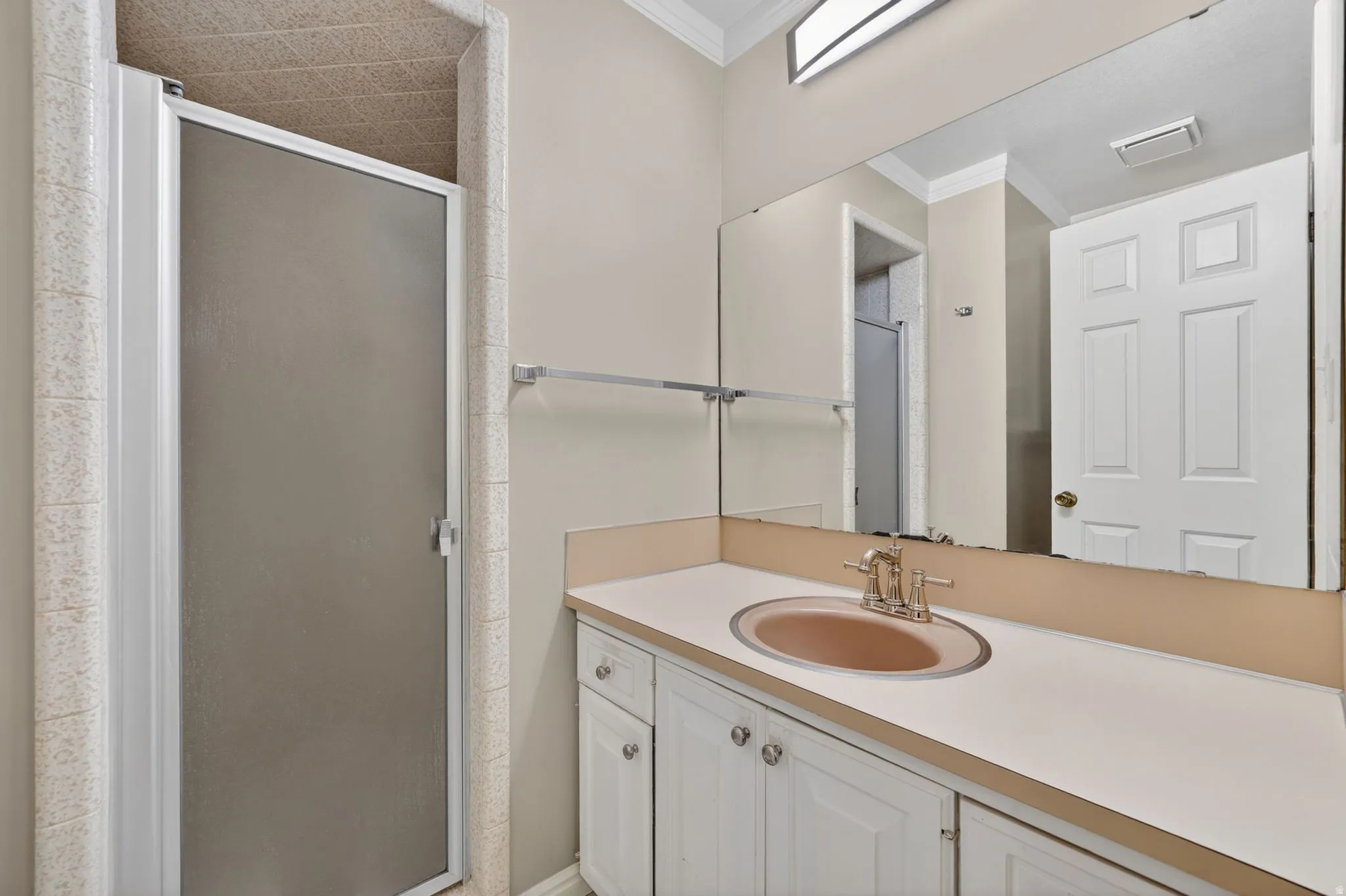 Bathroom vanity with a tan countertop, an integrated sink, and white cabinetry
