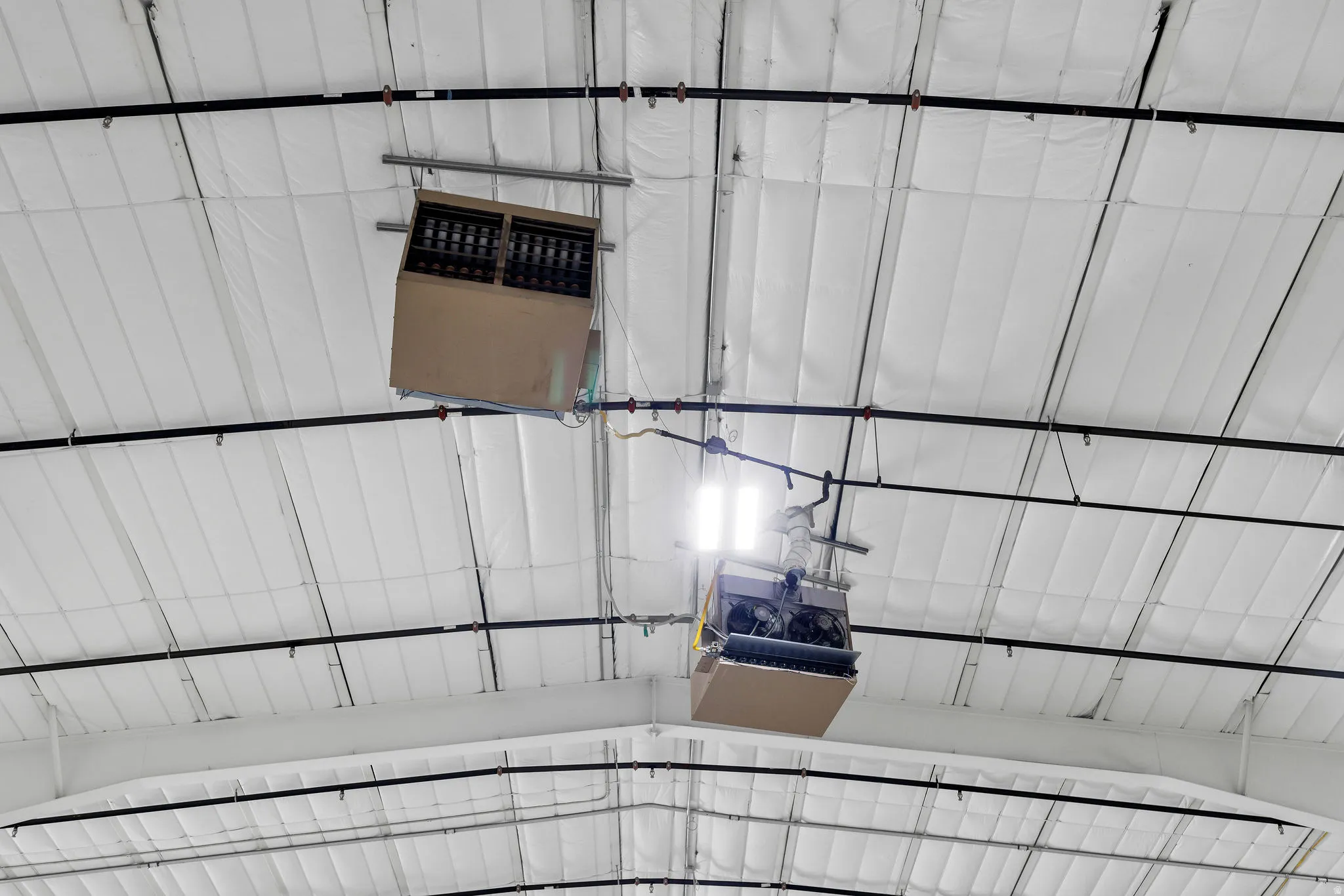 High-efficiency ceiling-mounted climate control units with exposed ductwork, structural beams, and insulated ceiling panels