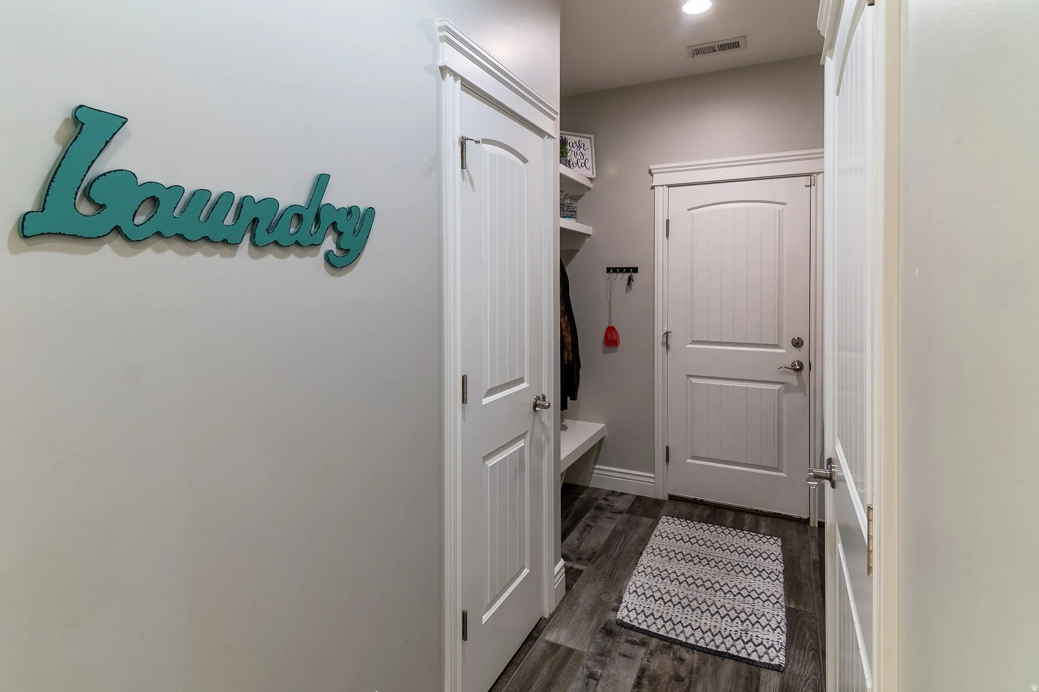 Mudroom with wood-finish flooring, built-in shelving, and a built-in bench