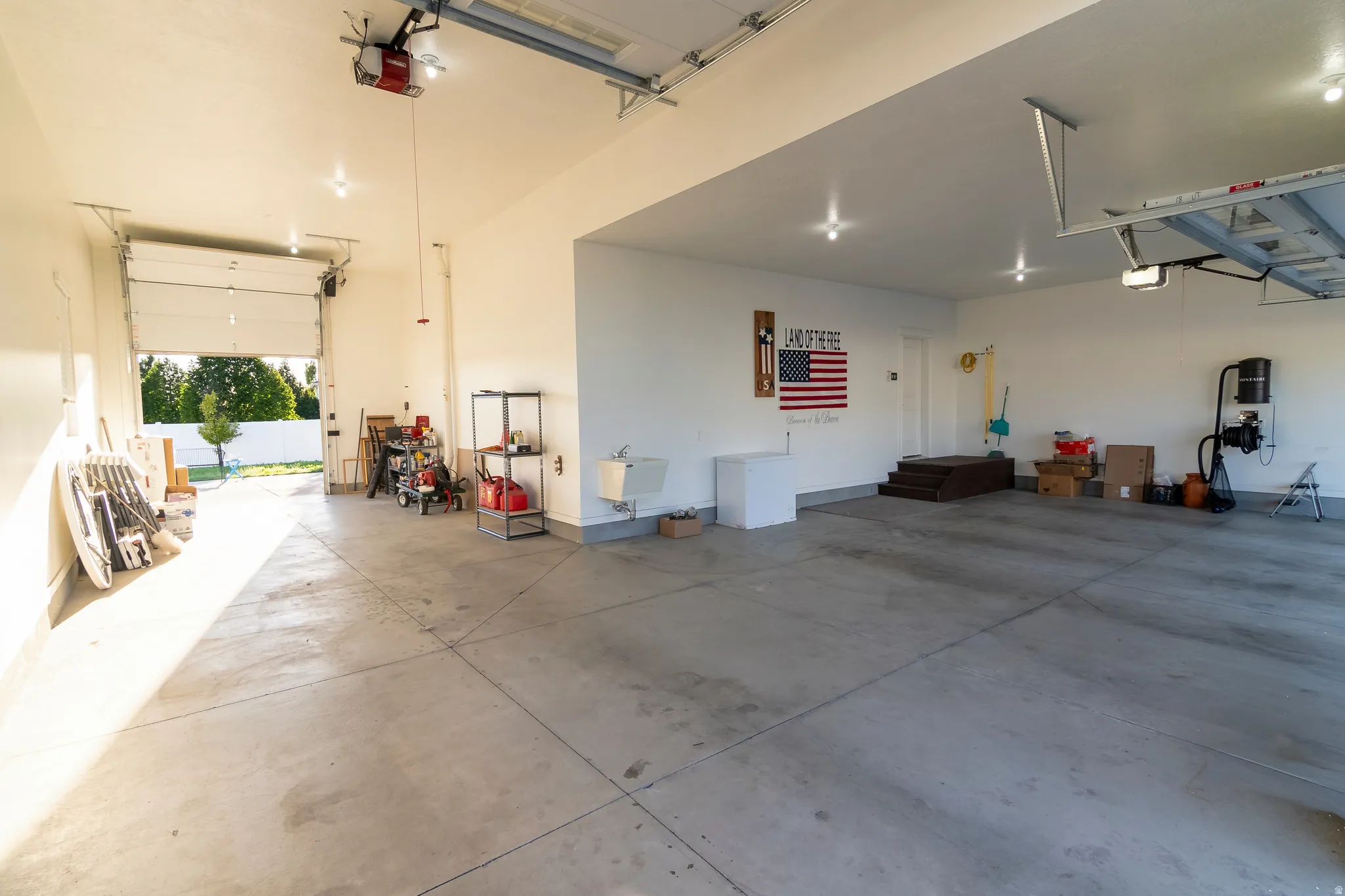 Spacious garage featuring a concrete floor, high ceilings, and an overhead garage door