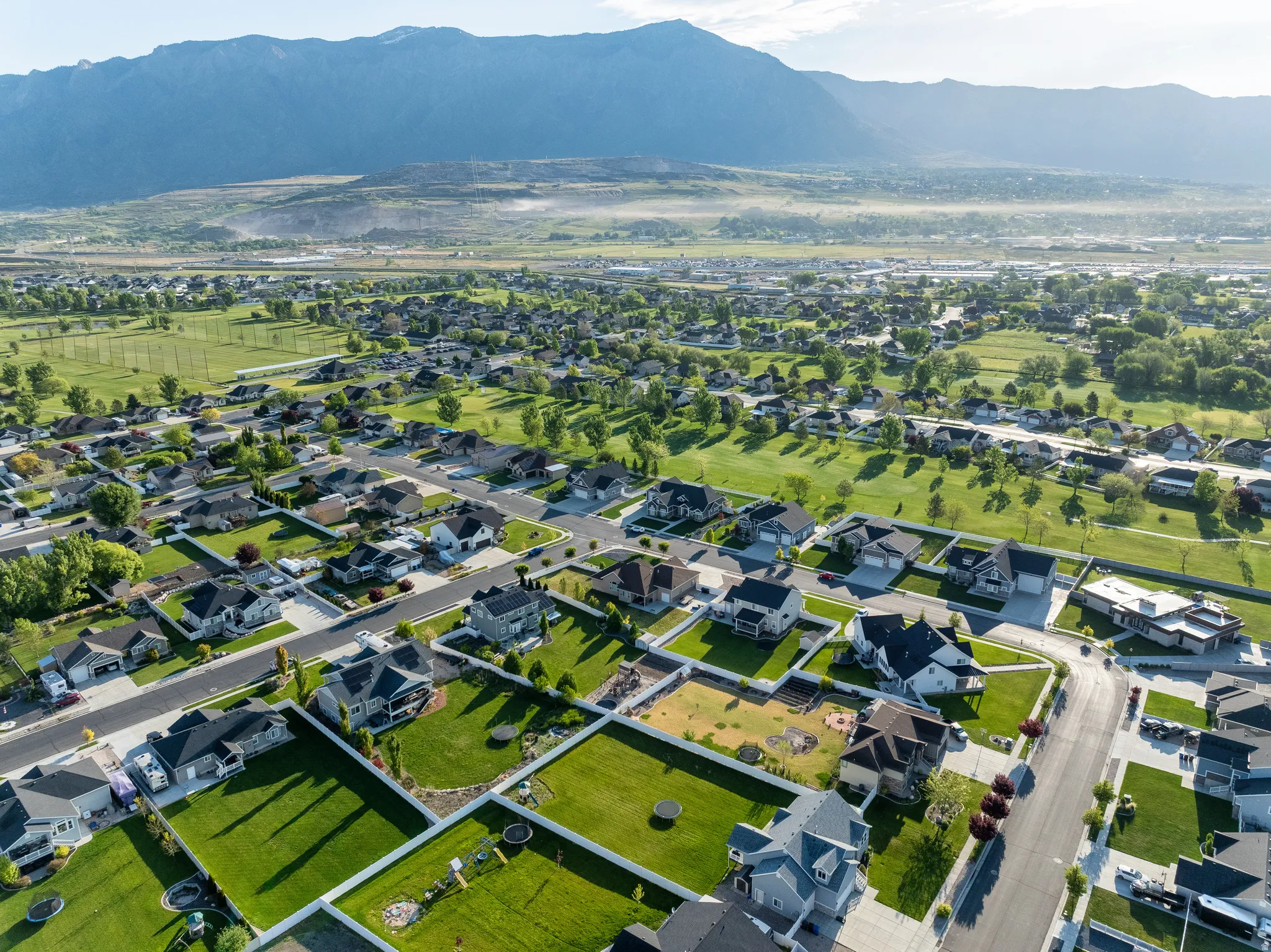 Expansive aerial view showcasing a residential neighborhood with a mountainous backdrop