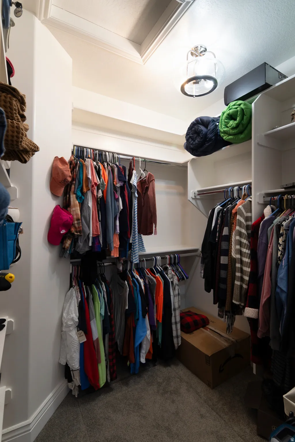 Built-in closet system featuring multiple hanging rods, overhead shelving, recessed lighting, and a semi-flush mount ceiling fixture