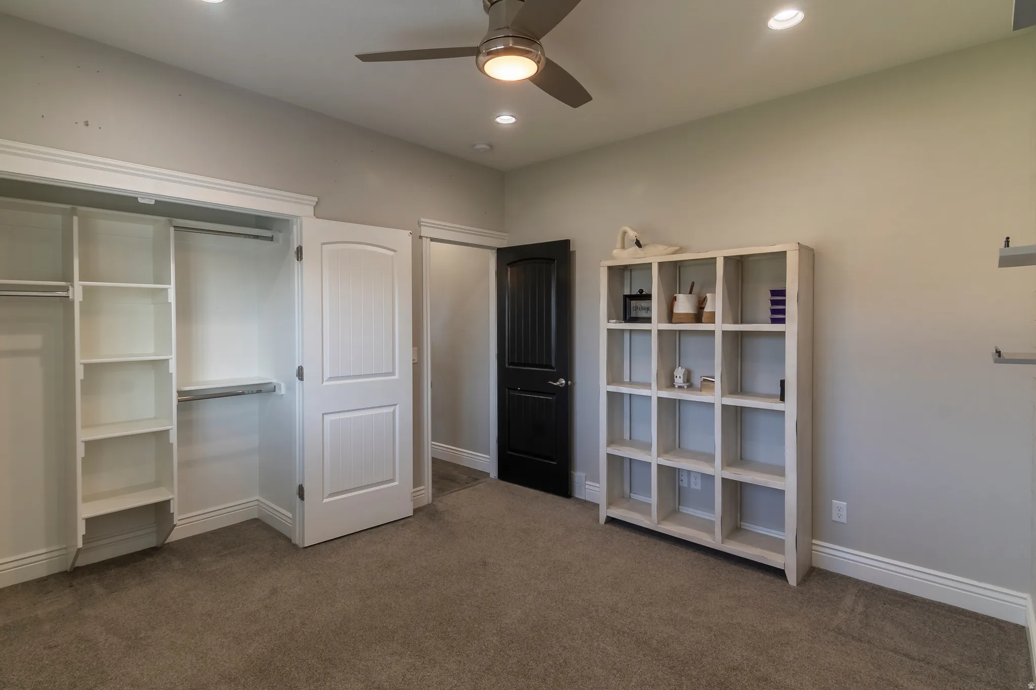 Bedroom featuring a built-in closet organization system, plush carpet flooring, recessed lighting, a ceiling fan, and white baseboards