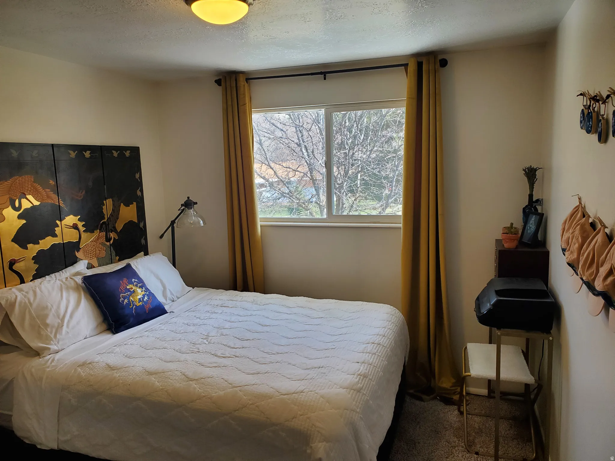 Bedroom featuring neutral wall paint, white trim, and a window with exterior tree views