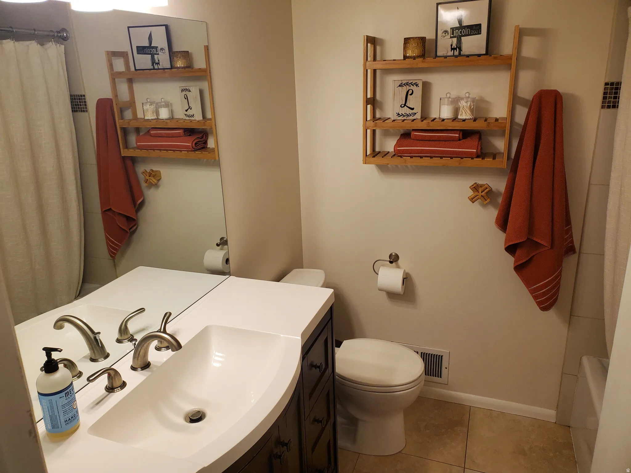 Bathroom featuring a dark wood-finish vanity with a white countertop and integrated rectangular sink