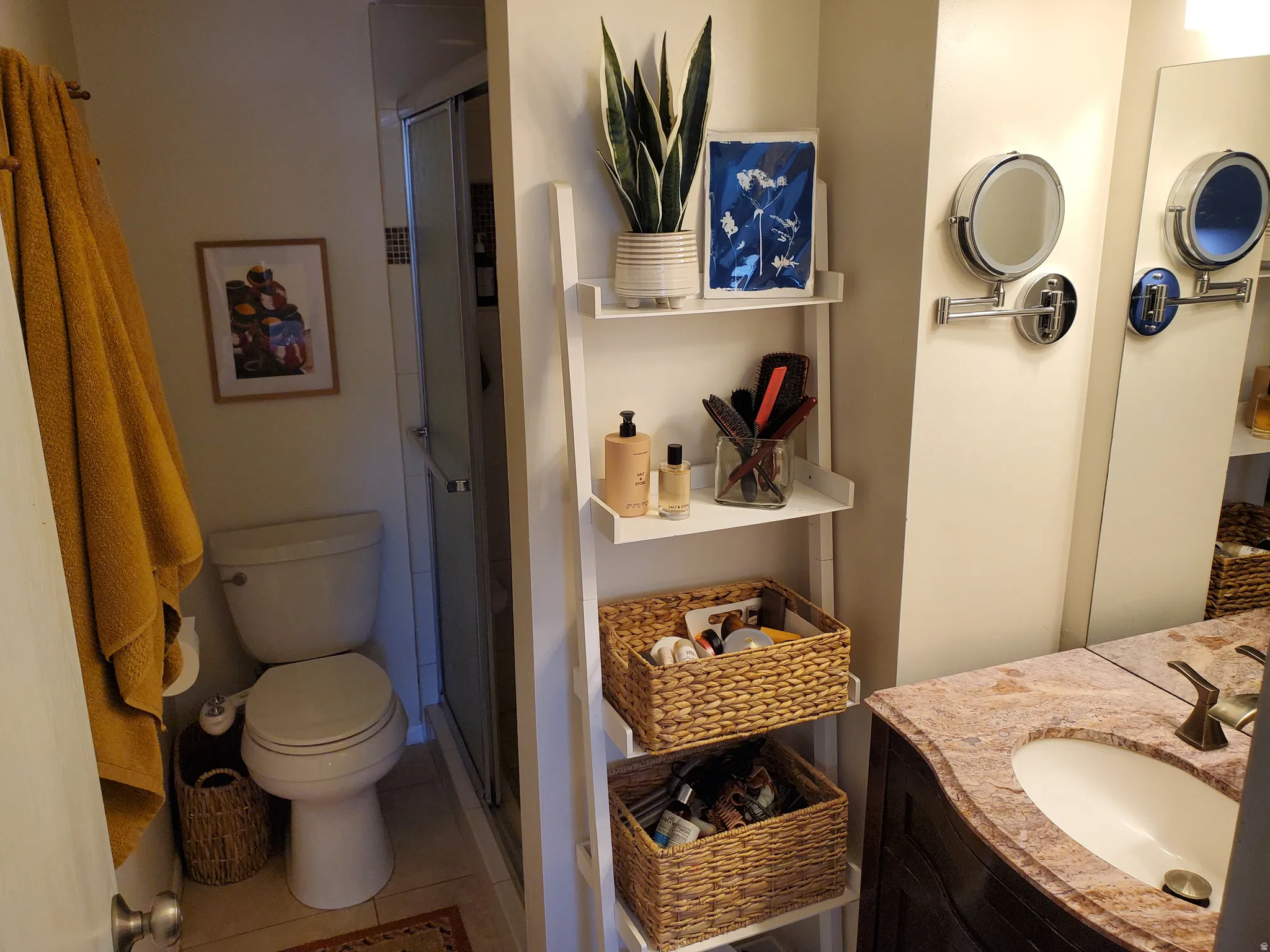 Bathroom featuring a shower enclosure, white toilet, and a vanity with a contoured countertop