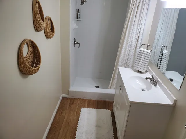 Bathroom featuring a white vanity with integrated sink, chrome faucet, and a large wall-mounted mirror