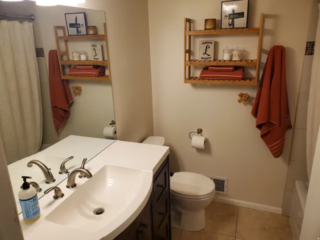 Bathroom featuring a dark wood-finish vanity with a white countertop and integrated rectangular sink