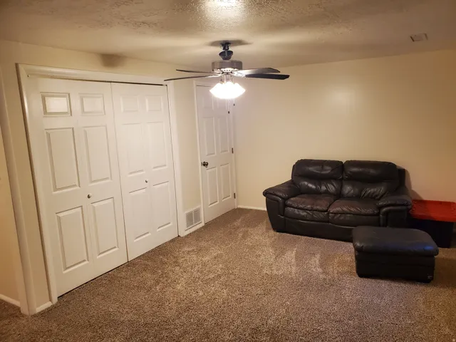 Neutral-toned wall paint complements the light brown carpeting