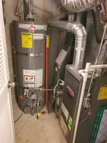 Utility space featuring a water heater and furnace unit