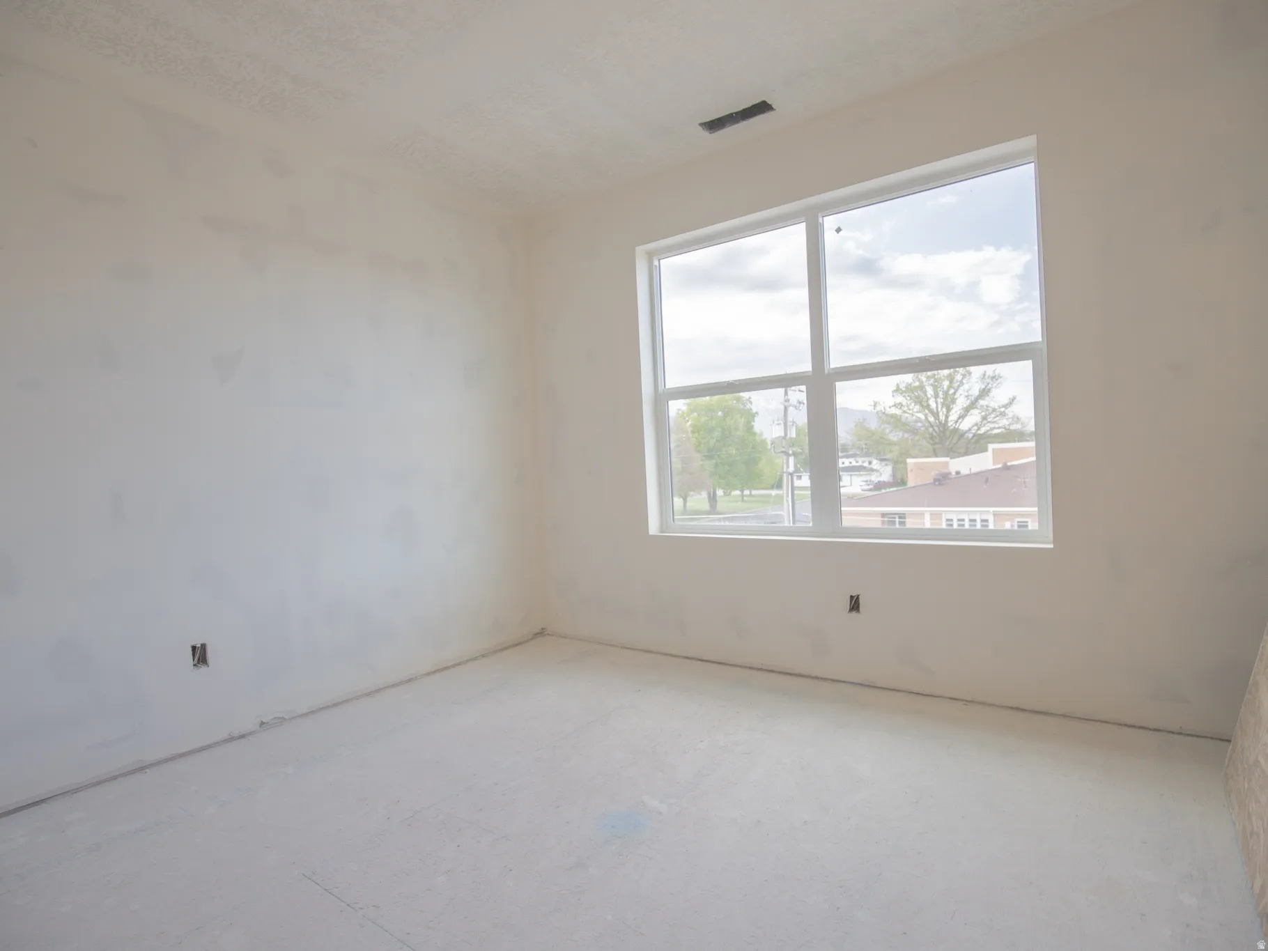 Room with unfinished walls and a large window