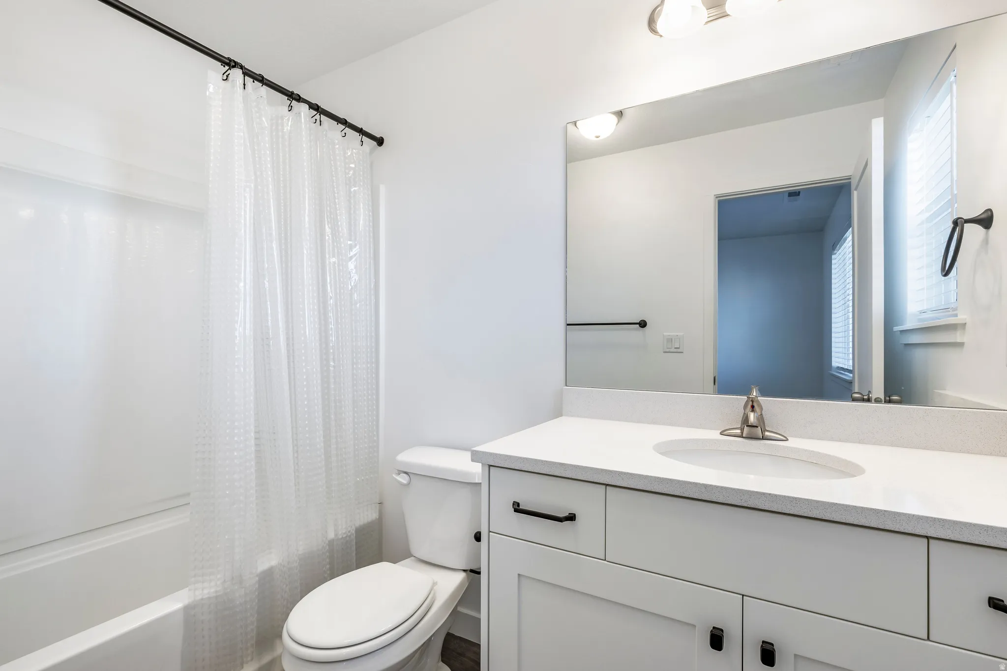 White vanity with a light-toned countertop, an integrated sink, and brushed nickel hardware