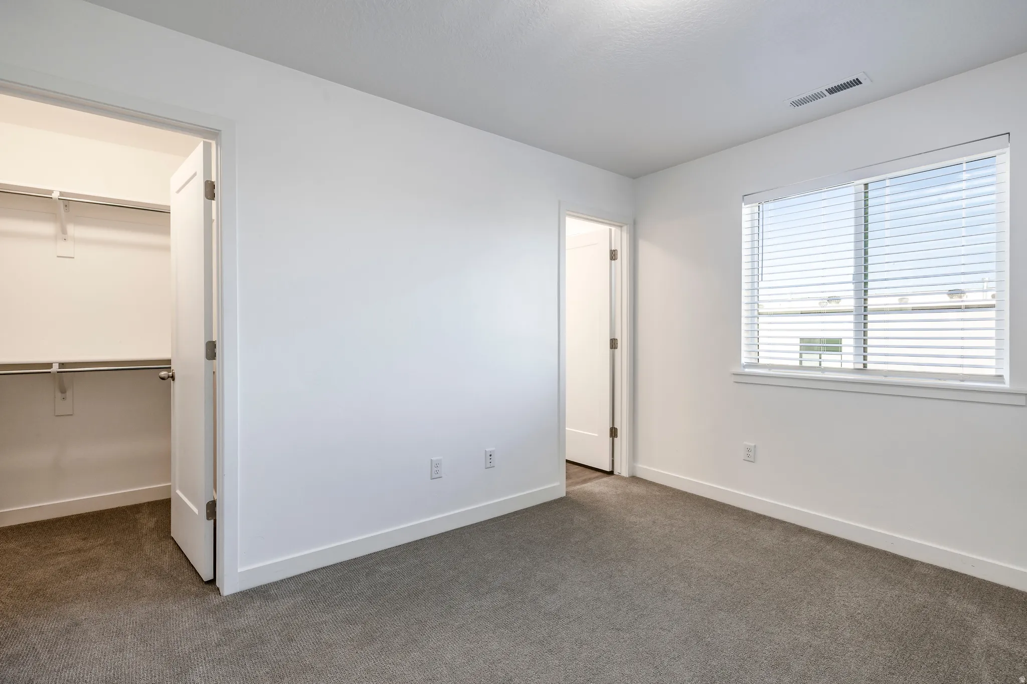 Bedroom featuring neutral carpeting, white walls, and white trim
