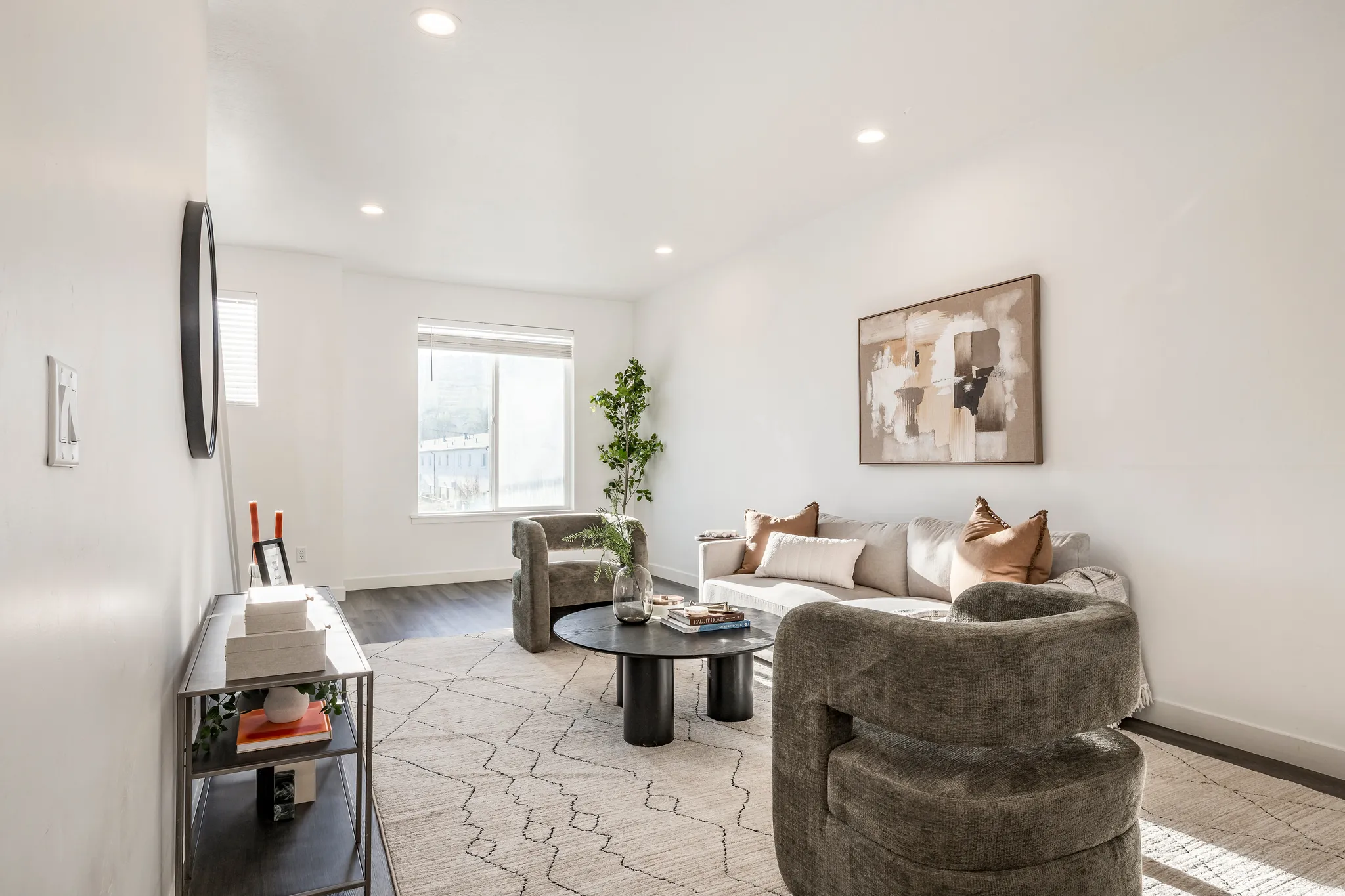 Bright living area featuring recessed lighting, dark wood-finish flooring, white walls, and a large window