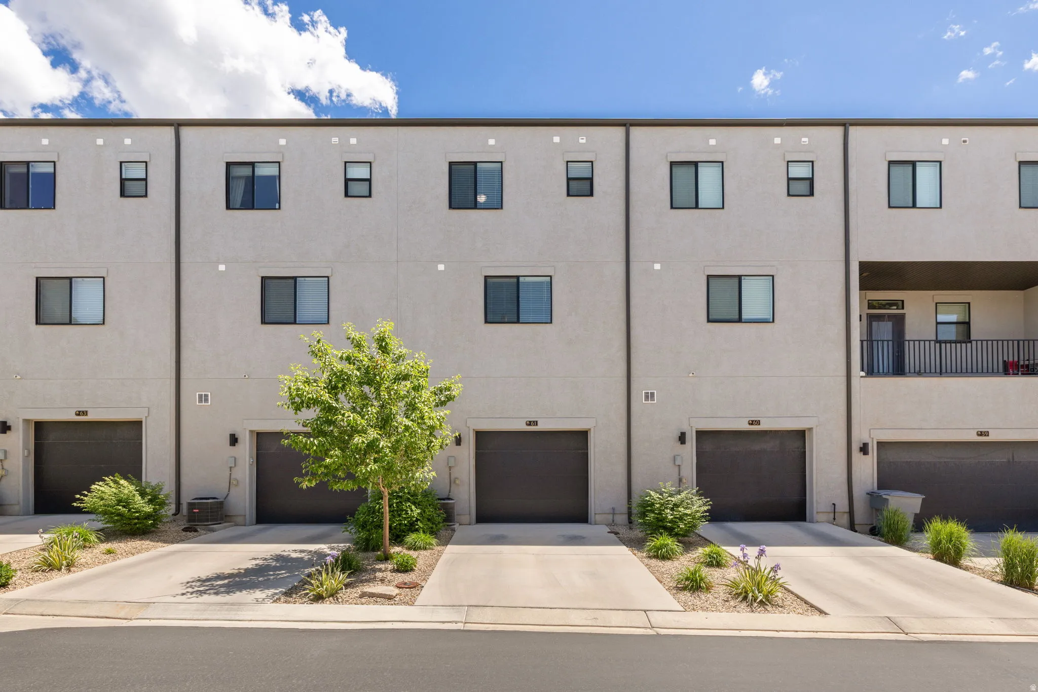 Modern townhome-style residences featuring stucco exteriors and dark-framed windows