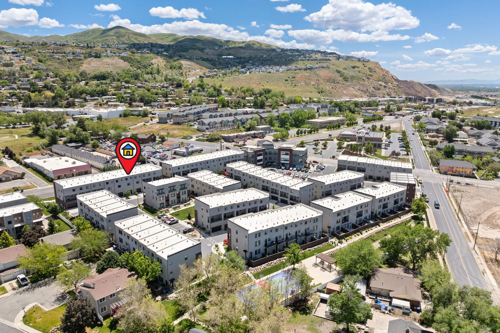 Aerial perspective showcasing a modern residential development with a mountainous backdrop
