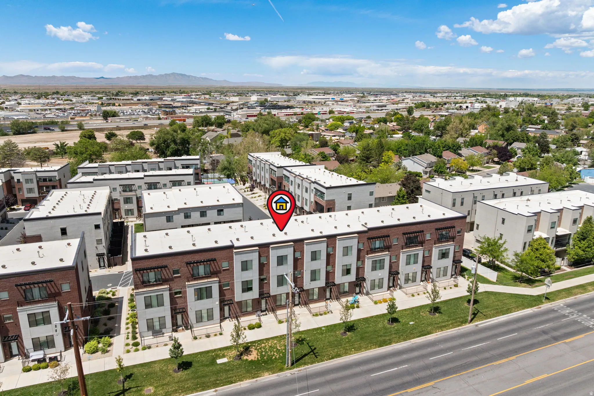 Modern townhome complex featuring multi-story units with brick and panel exteriors