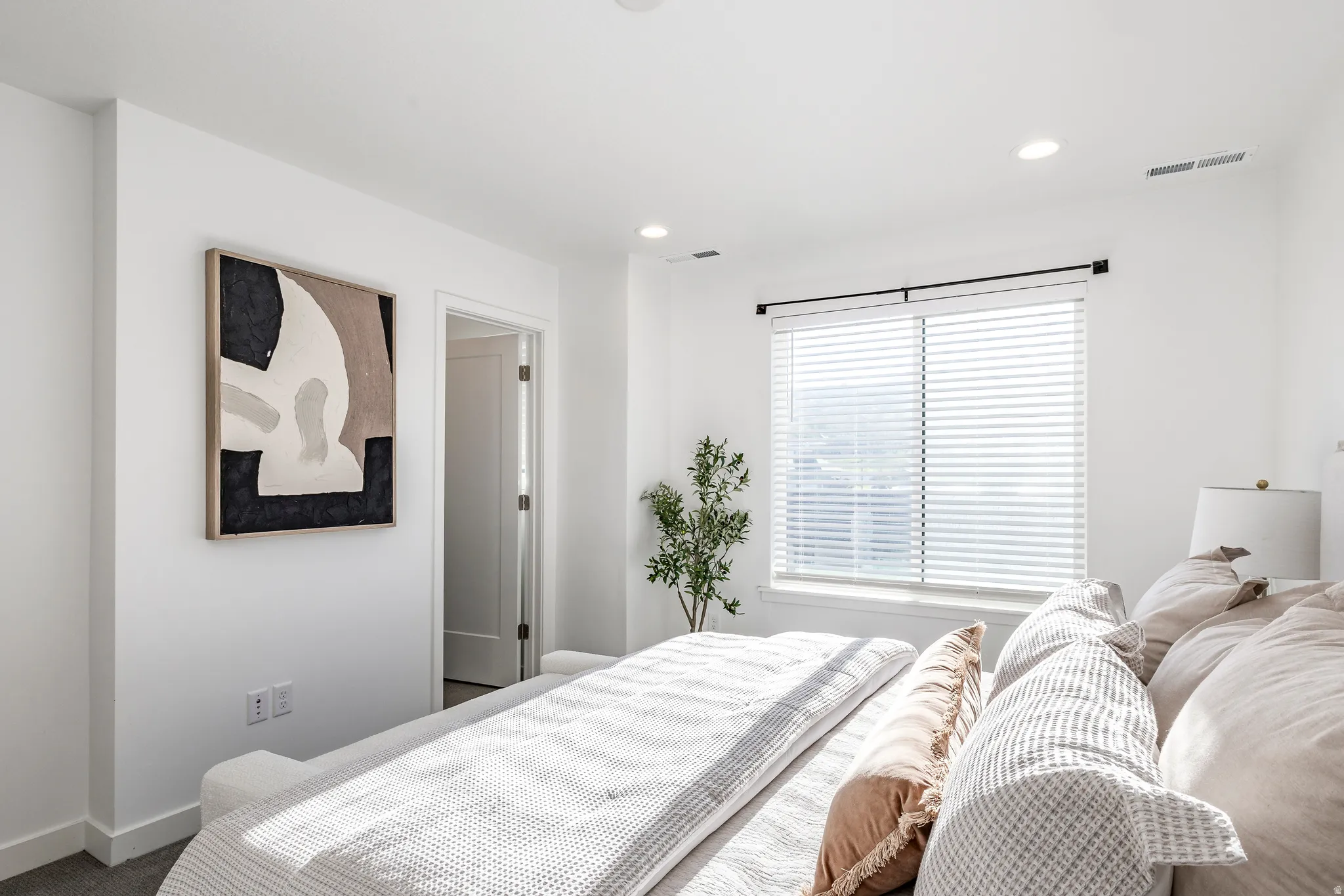 Bedroom featuring recessed lighting, a large window with blinds, and white trim