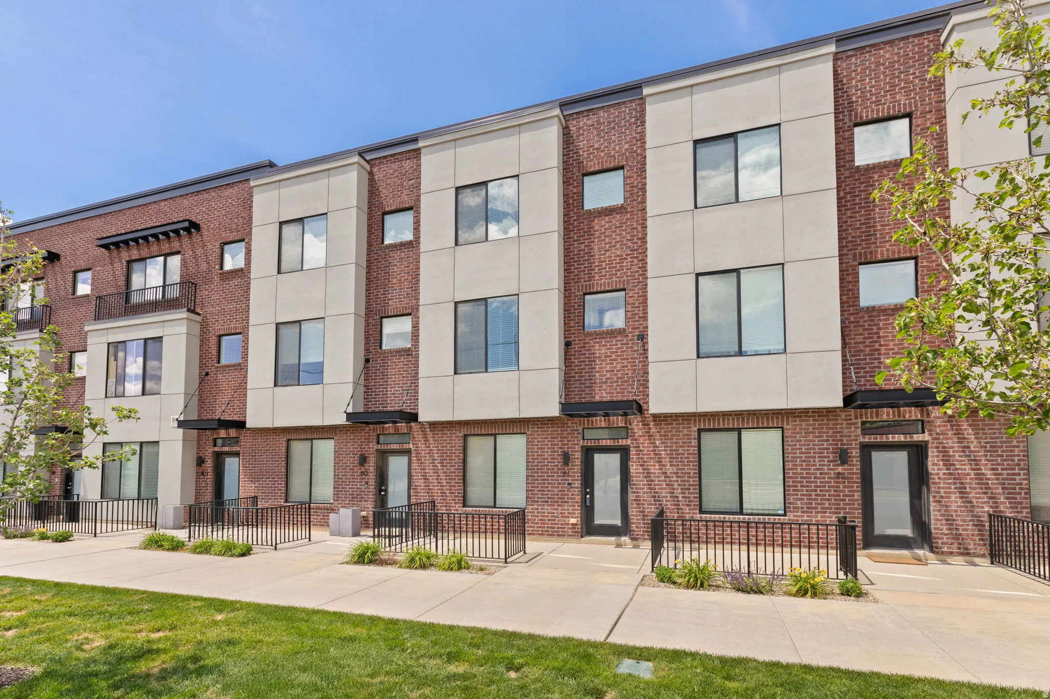 Townhome exterior featuring brick and light-colored panel siding