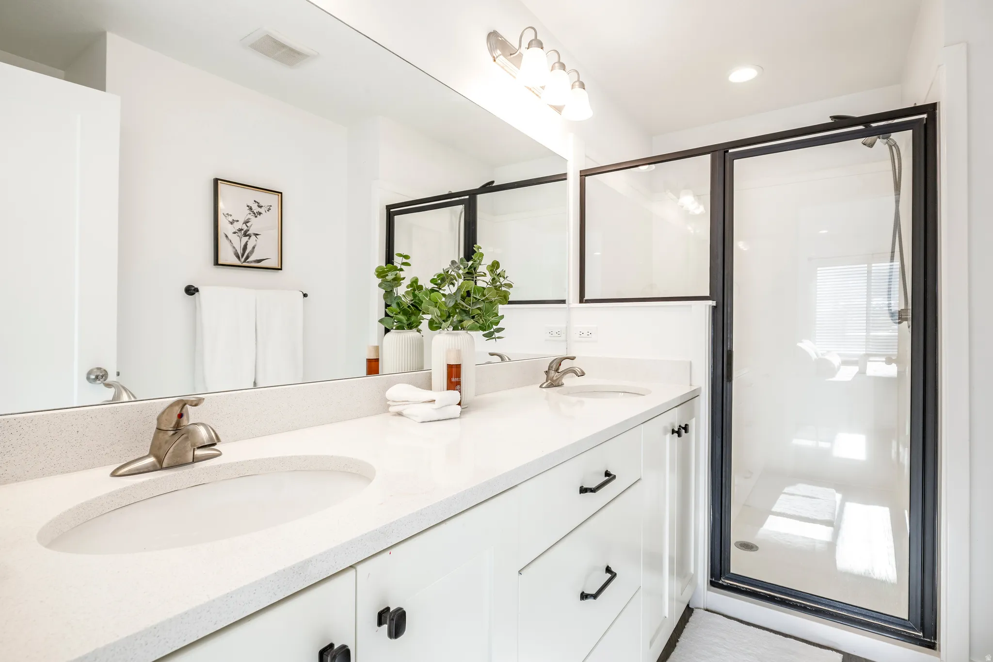 Double vanity with light-colored countertops, undermount sinks, and brushed nickel faucets