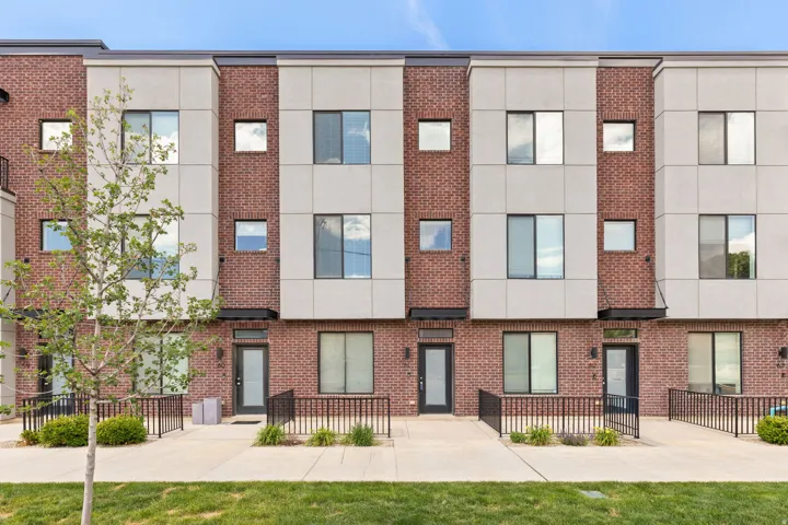 Contemporary townhome with a brick and panel facade