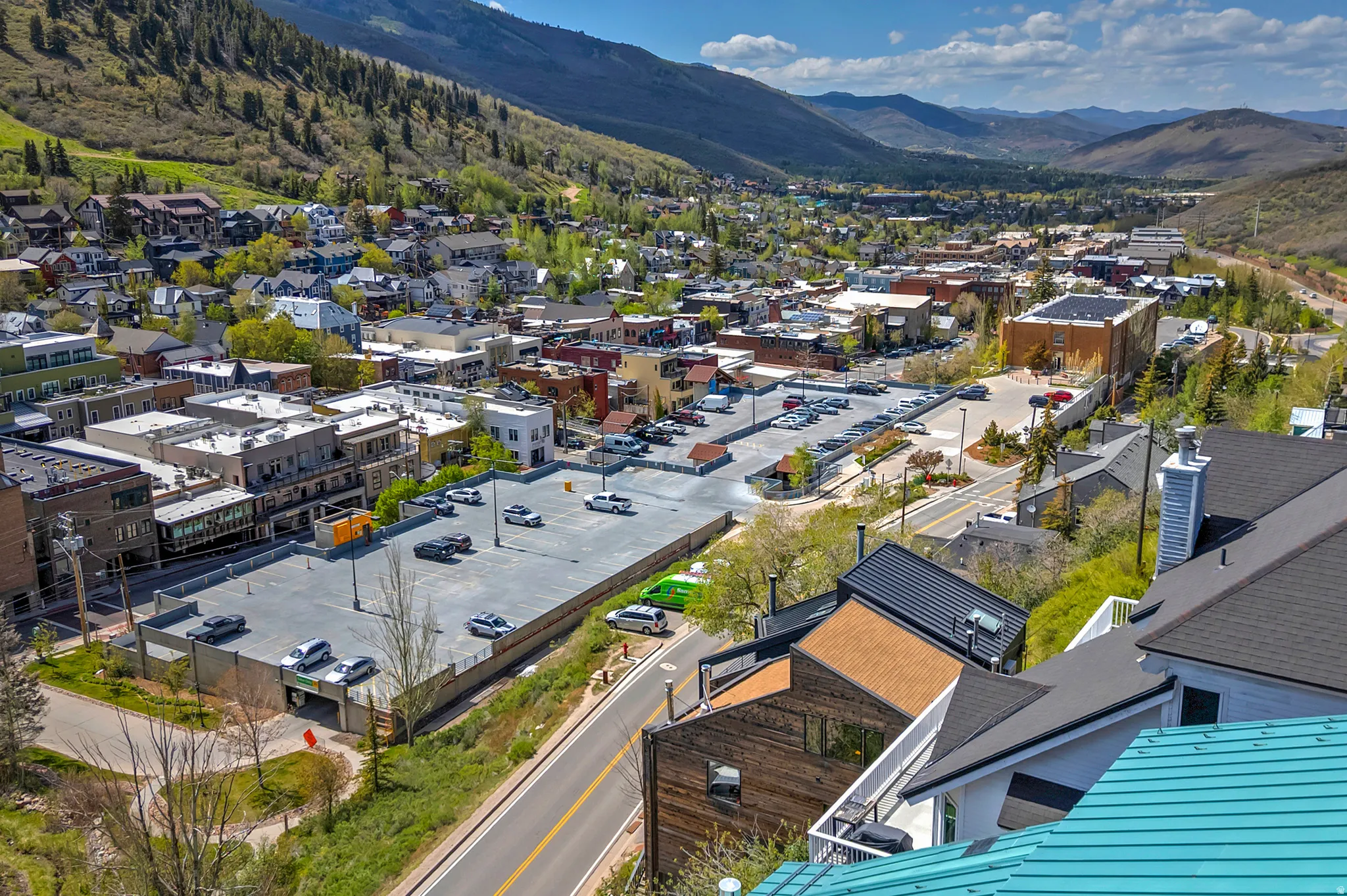 Expansive mountain valley landscape featuring a town, commercial buildings, and residential structures with varied rooflines