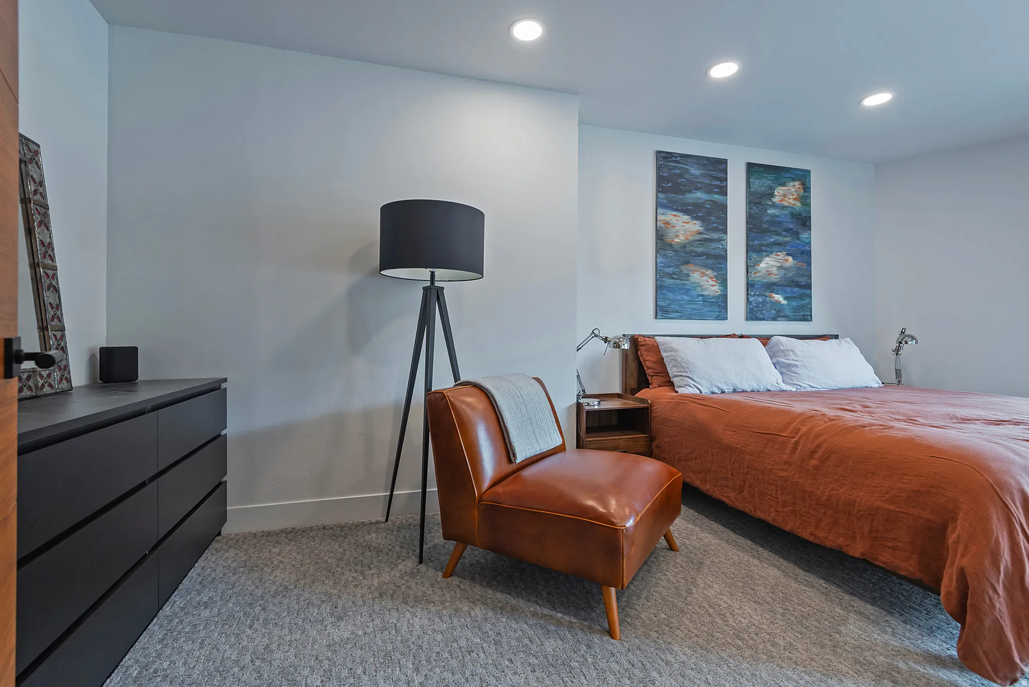 Recessed lighting illuminates the room with light gray carpeting