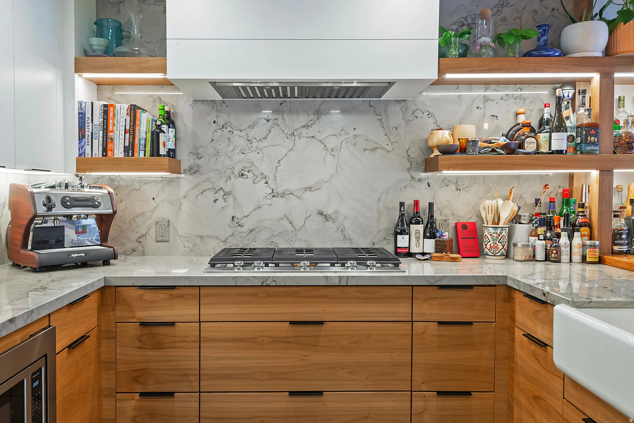 Contemporary kitchen featuring wood-finish cabinetry, light-toned countertops, and a full-height backsplash