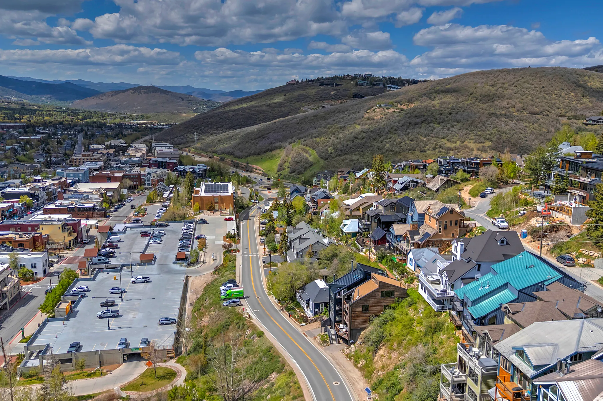 Aerial perspective of a hillside community featuring multi-level residences with diverse architectural styles