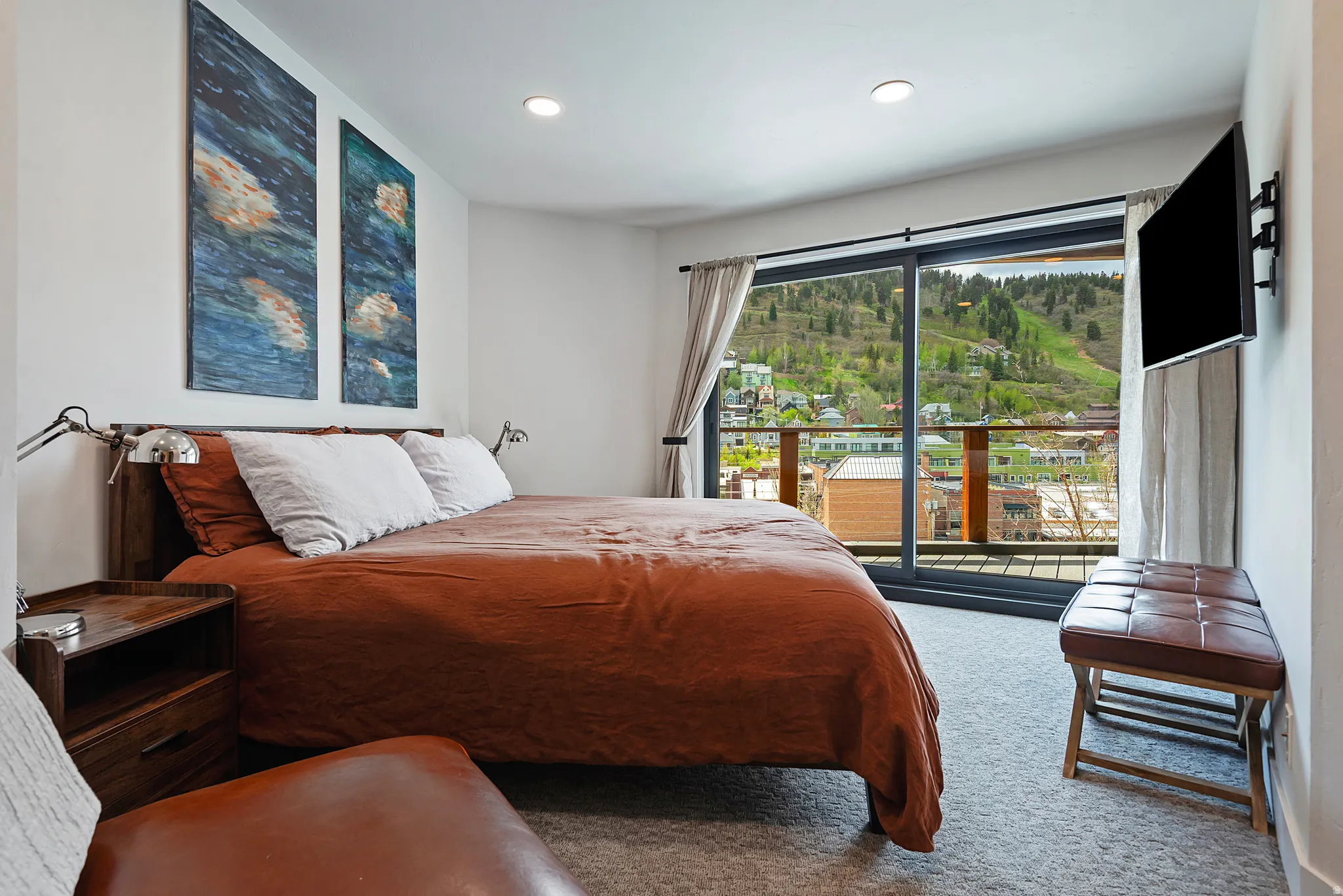 Bedroom featuring a full glass sliding door, balcony access, recessed lighting, and soft gray carpeting