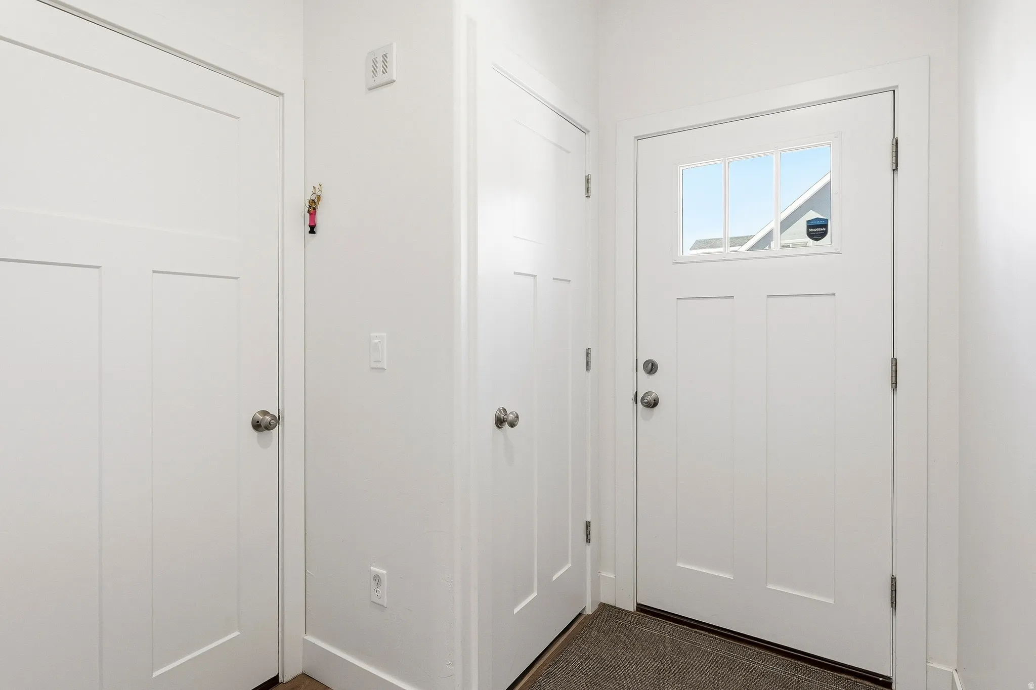 Entryway featuring a white paneled door with glass inserts, brushed nickel hardware, and neutral wall tones