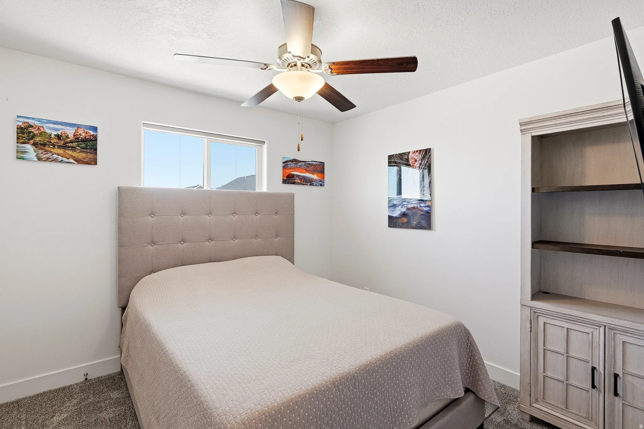 Bedroom featuring a picture window, neutral carpeting, and white baseboards