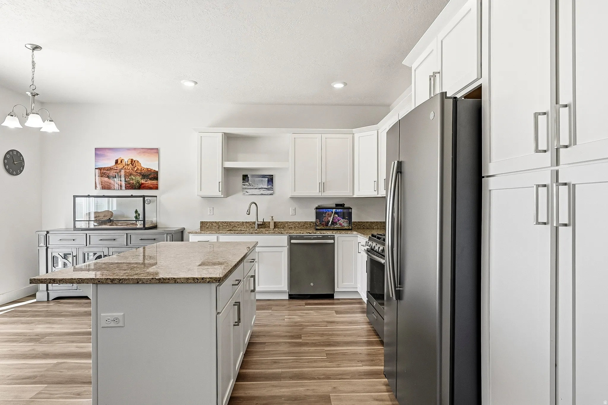 Kitchen featuring white cabinetry, granite countertops, and wood-finish flooring