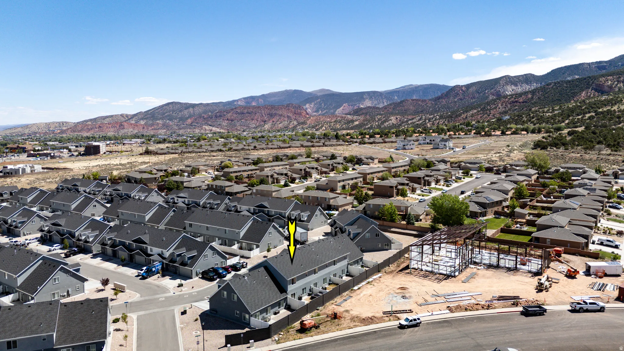 Townhome property featuring a two-story design with a grey exterior and dark shingle roof