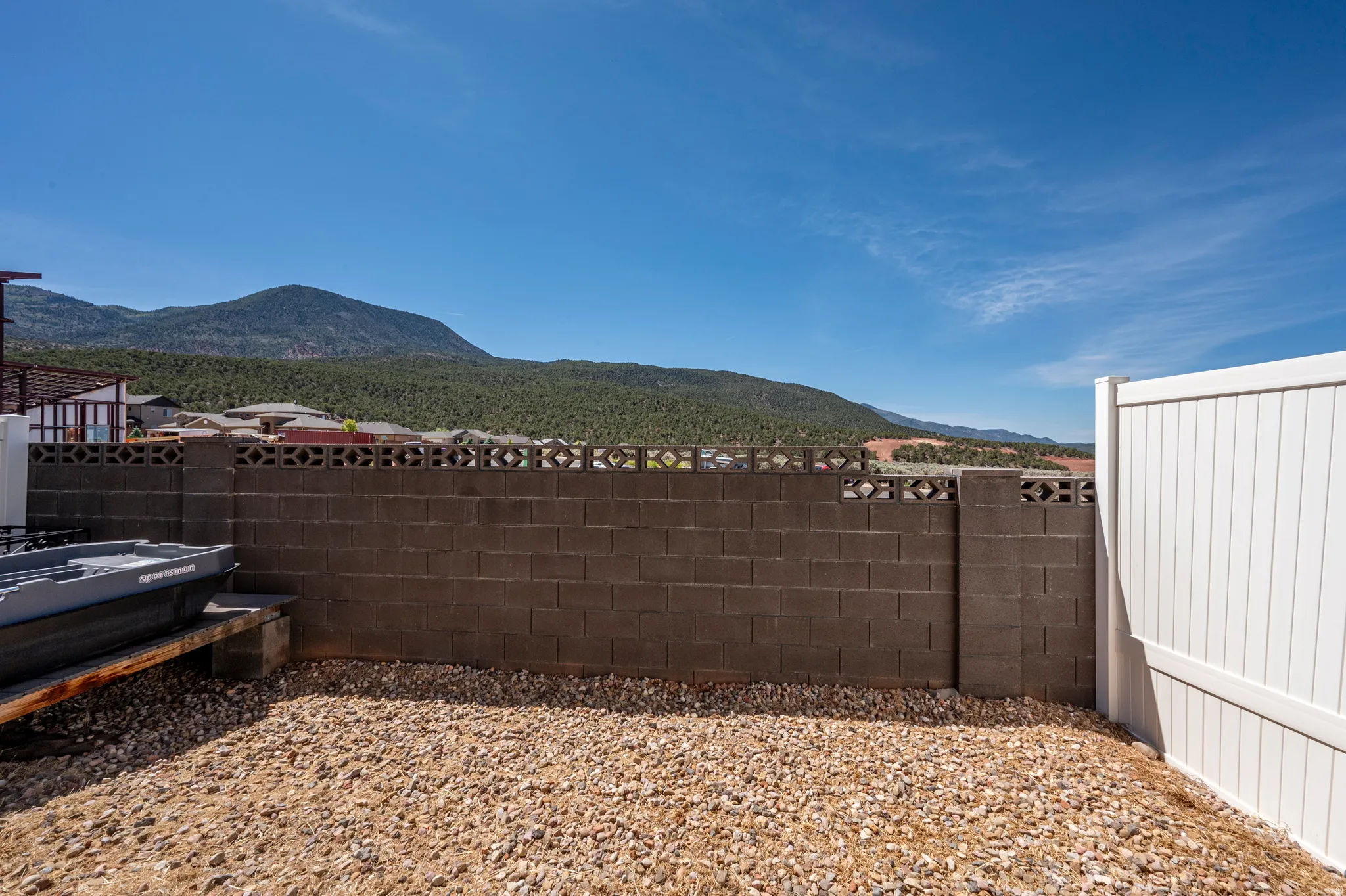 Xeriscape landscaping with gravel and a concrete block privacy wall
