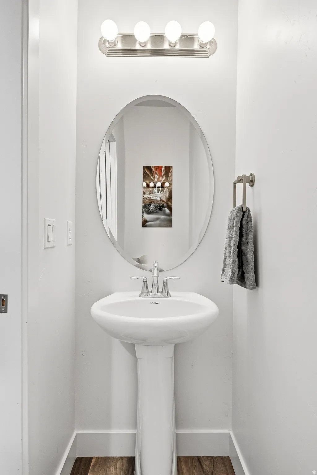Pedestal sink vanity with chrome faucet and oval mirror