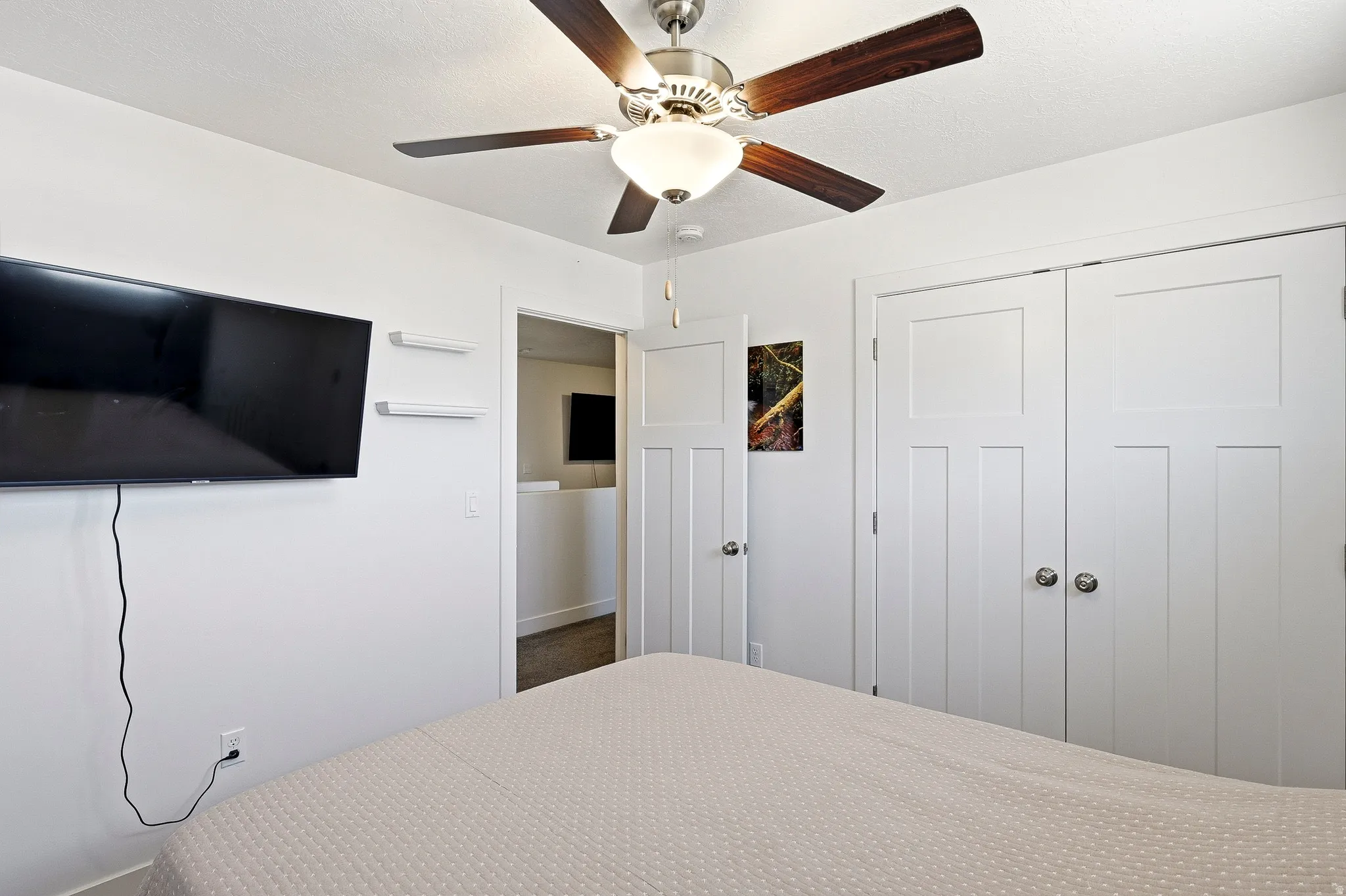White interior walls complemented by a ceiling fan with wood-finish blades and integrated lighting