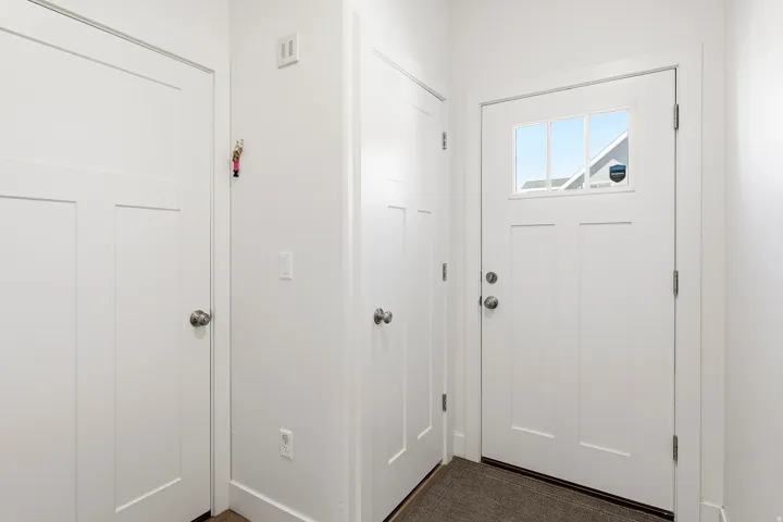 Entryway featuring a white paneled door with glass inserts, brushed nickel hardware, and neutral wall tones