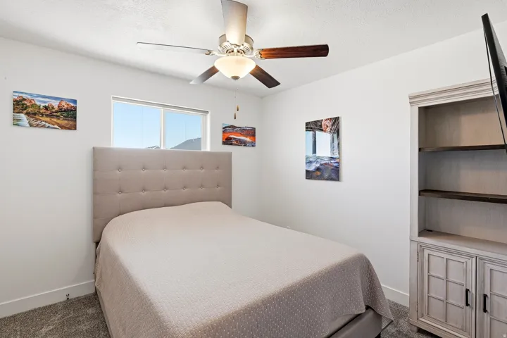 Bedroom featuring a picture window, neutral carpeting, and white baseboards