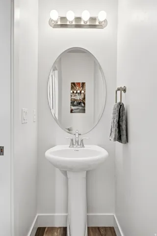 Pedestal sink vanity with chrome faucet and oval mirror